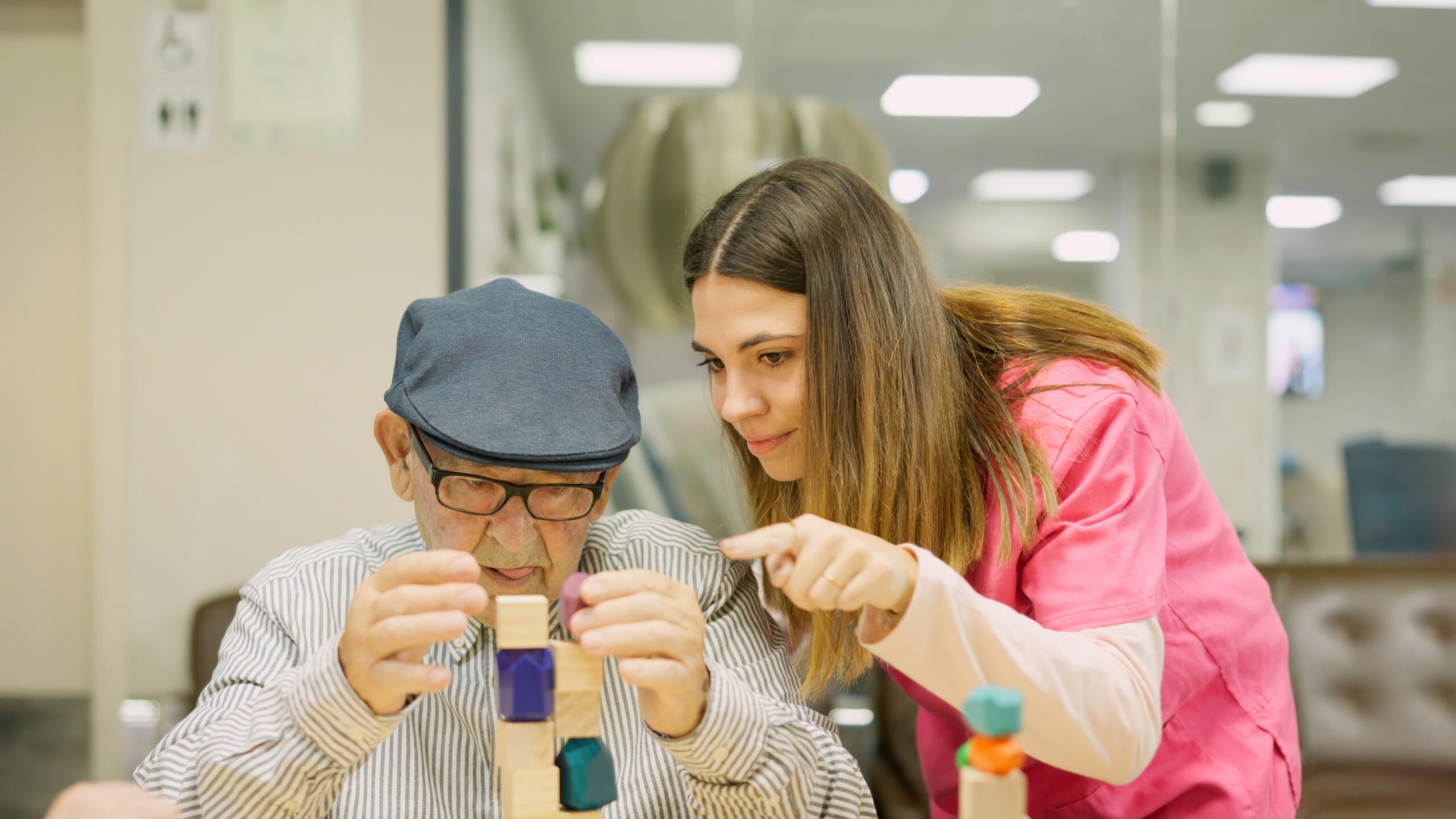 Man with building blocks being helped by female care worker